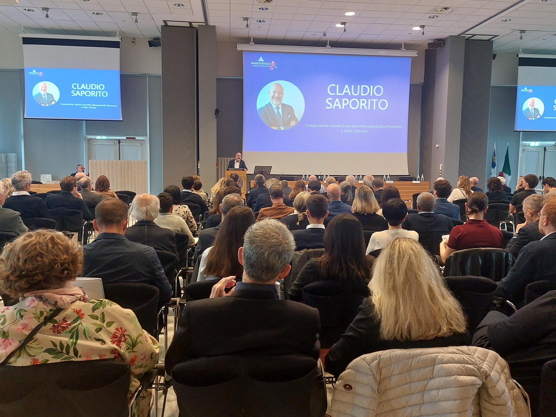 persone viste di spalle partecipano all'assemblea di manageritalia piemonte vda